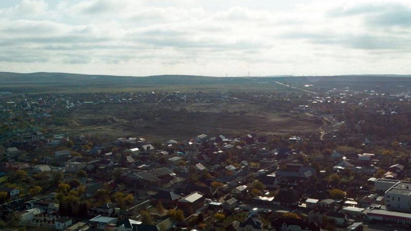 Вид с высоты на урочище Турецкий фонтан в станице Тамань с северной стороны, за южной окраиной станицы возвышается Таманская гряда, фото ноябрь 2021 г.